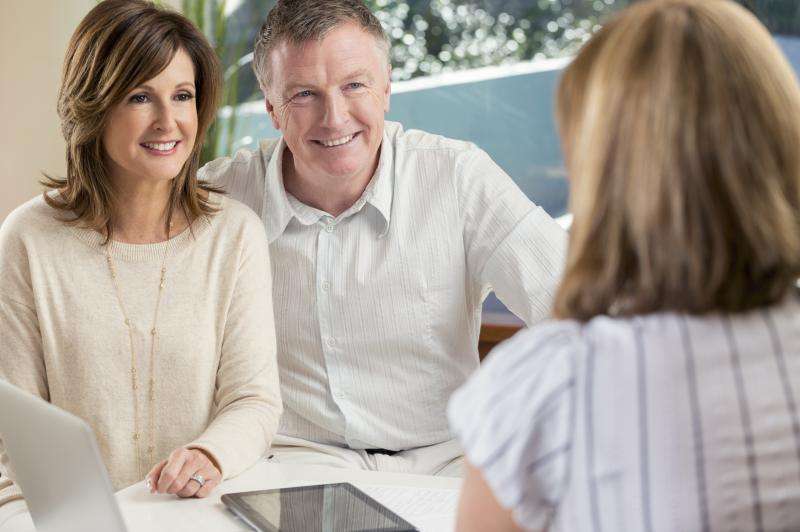 Happy mature couple meeting with advisor at home
