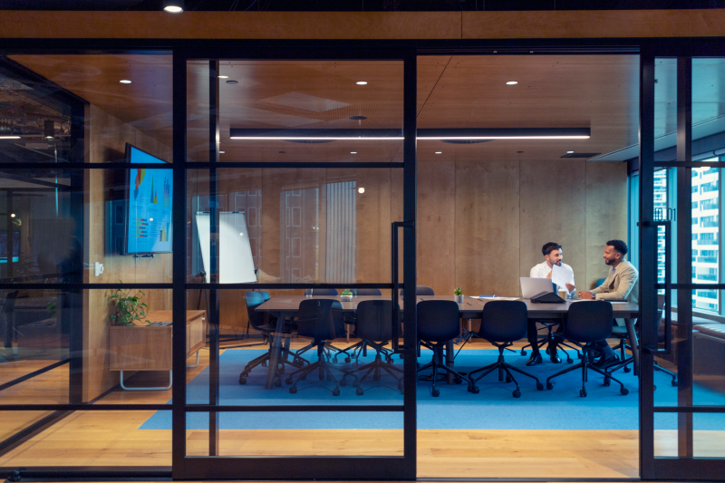 Business people working in a board room with a laptop and digital tablet. Manager working with an employee, job interview, sales, lawyer or a financial advisor.